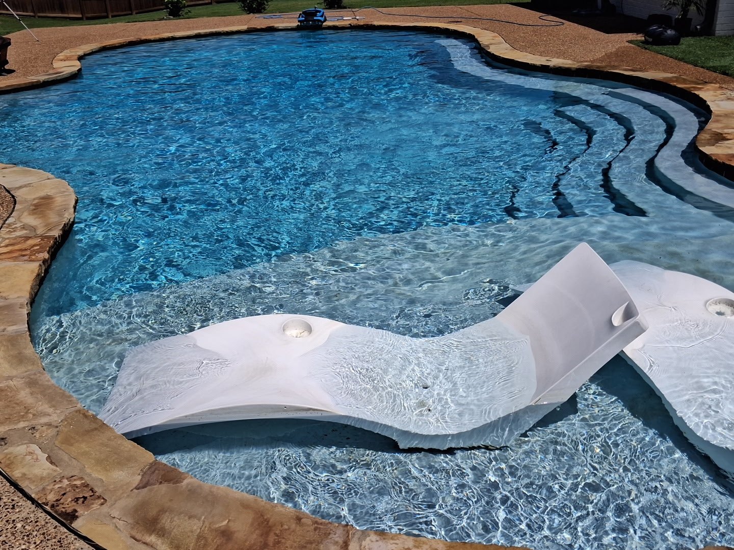 Clear swimming pool with tanning ledge